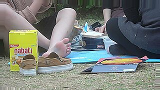 Młoda Azjatka pokazuje swoje stopy w parku.