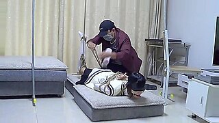 Una mujer asiática atada soporta una intensa escena BDSM.