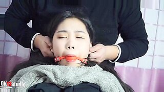 묶인 아시아 미녀가 페티쉬 플레이에서 장난감을 입에 넣습니다